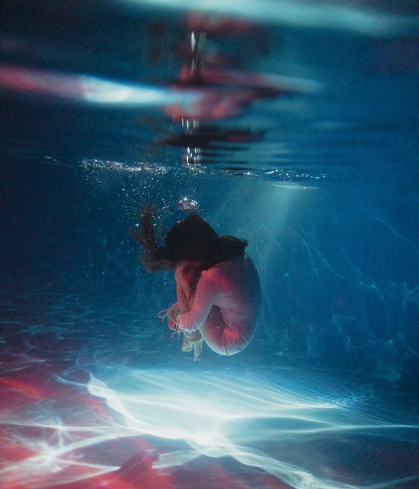 Woman in a graceful yoga pose with serene blue light accents.